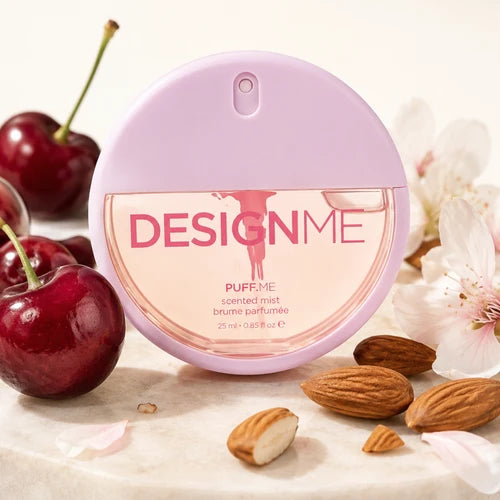 Brume parfumé rond de couleur rose écrit Design me de la gamme puff me démontrant autour des cerises, des amandes et des fleurs pour l'odeur.
